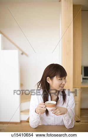 Picture - Young woman having cup of coffee. Fotosearch