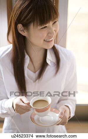 Picture - Young woman having cup of coffee. Fotosearch