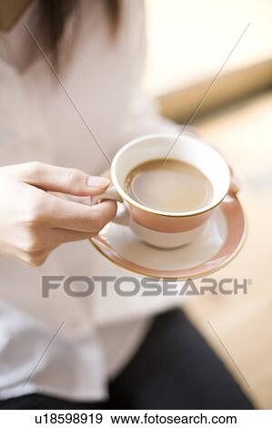 Young woman having cup of coffee View Large Photo Image Stock Photo - Young woman having cup of coffee. Fotosearch