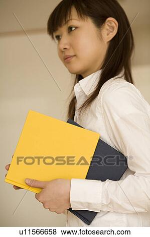 Young woman holding books View Large Photo Image Stock Photo - Young woman holding books. Fotosearch