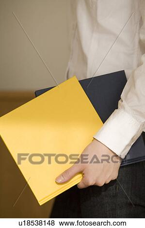 Stock Photo - Young woman holding books. Fotosearch