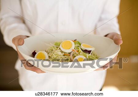 Stock Photo - Young woman holding bowl of salad. Fotosearch