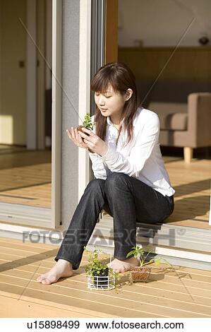 Stock Photo - Young woman looking at plants. Fotosearch