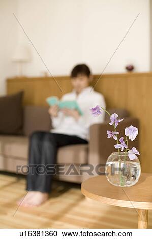 Young woman reading book sitting on sofa View Large Photo Image Stock Image - Young woman reading book sitting on sofa. Fotosearch