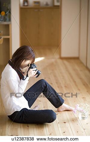 Young woman taking photo of flowers View Large Photo Image Stock Photo - Young woman taking photo of flowers. Fotosearch