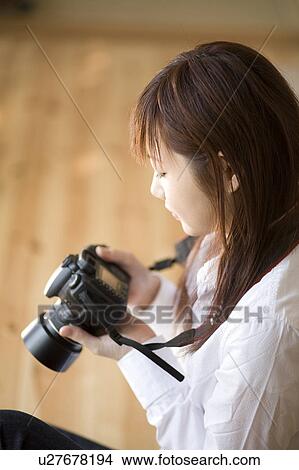 Picture - Young woman using camera. Fotosearch