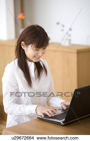 Picture - Young woman using computer. Fotosearch