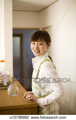 Stock Image - Young woman wearing apron. Fotosearch
