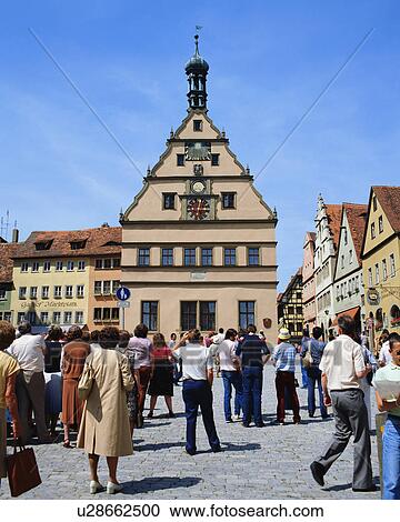 Stock Image - Large group of people watching clock tower in Rothenburg, Germany. Fotosearch