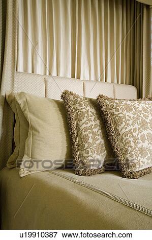 Stock Photo - Detail of neutral toned decorative pillows on bed. Fotosearch