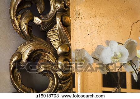 Stock Image - Orchids in ornate gold mirror. Fotosearch