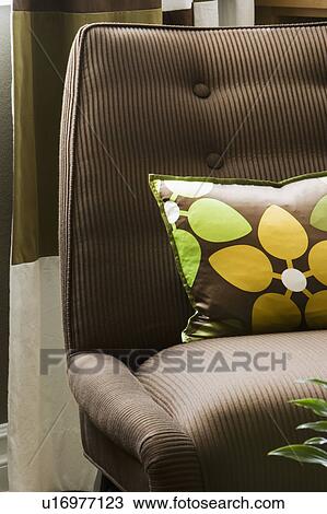 Stock Image - Brown Chair with flower pillow. Fotosearch