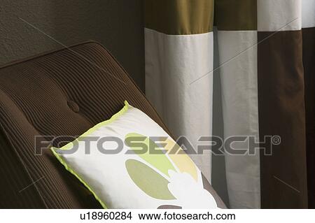 Picture - Contemporary Brown Chair with Flower Pillow. Fotosearch