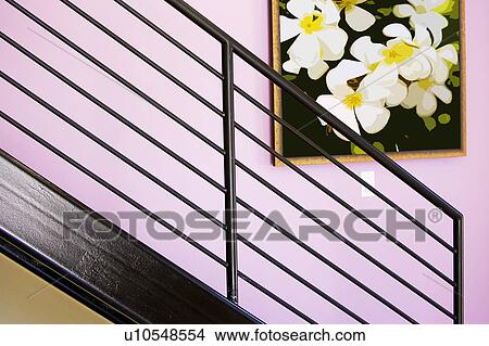 Painting hanging on a wall behind a stair railing View Large Photo Image Picture - Painting hanging on a wall behind a stair railing. Fotosearch