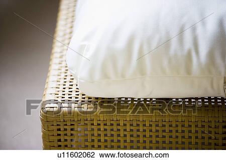 Stock Image - Woven Wicker Patio Furniture with White Cushion. Fotosearch
