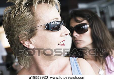 Close-up of a mature woman and a mid adult woman wearing sunglasses View Large Photo Image Stock Image - Close-up of a mature woman and a mid adult woman wearing sunglasses. Fotosearch