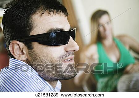 Close-up of a young man smiling with a mid adult woman sitting on a chair in the background View Large Photo Image Stock Photo - Close-up of a young man smiling with a mid adult woman sitting on a chair in the background. Fotosearch