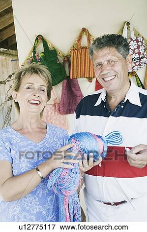 Stock Photo - Mature woman holding a bundle of synthetic threads with a senior man standing beside her. Fotosearch