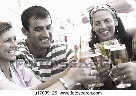 Mid adult man and two mid adult women toasting with beer glasses and smiling View Large Photo Image Stock Photography - Mid adult man and two mid adult women toasting with beer glasses and smiling. Fotosearch