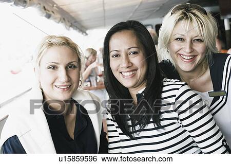 Stock Photograph - Portrait of three friends smiling. Fotosearch