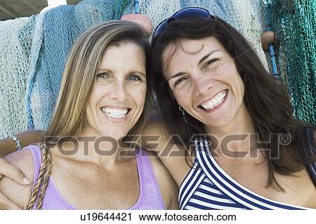 Portrait of two mid adult women smiling View Large Photo Image Stock Image - Portrait of two mid adult women smiling. Fotosearch