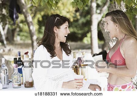 Two mid adult women drinking wine on the beach View Large Photo Image Stock Image - Two mid adult women drinking wine on the beach. Fotosearch