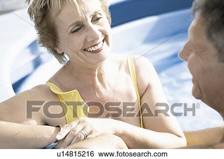 Stock Photograph - Close-up of a mature woman and a senior man smiling in a swimming pool. Fotosearch