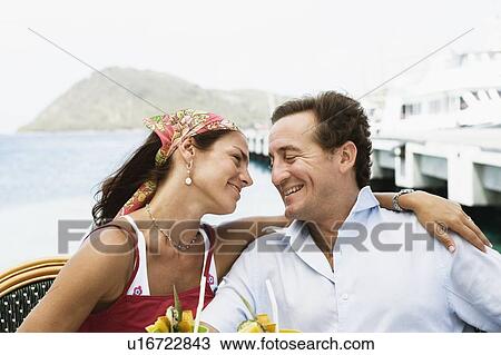 Stock Image - Close-up of a mid adult couple looking at each other and smiling. Fotosearch
