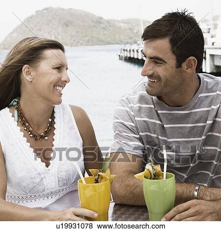 Close-up of a mid adult couple looking at each other and smiling View Large Photo Image Stock Photo - Close-up of a mid adult couple looking at each other and smiling. Fotosearch