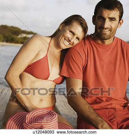 Portrait of a mid adult couple sitting on a pier and smiling View Large Photo Image Stock Image - Portrait of a mid adult couple sitting on a pier and smiling. Fotosearch