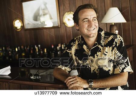 Close-up of a mid adult man sitting in a restaurant View Large Photo Image Stock Photo - Close-up of a mid adult man sitting in a restaurant. Fotosearch