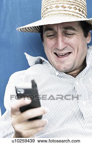 Close-up of a mid adult man text messaging on a mobile phone View Large Photo Image Stock Photo - Close-up of a mid adult man text messaging on a mobile phone. Fotosearch