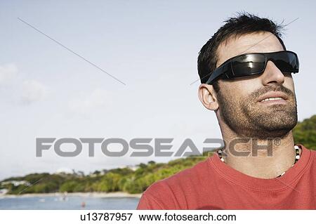 Stock Photo - Close-up of a mid adult man wearing sunglasses. Fotosearch