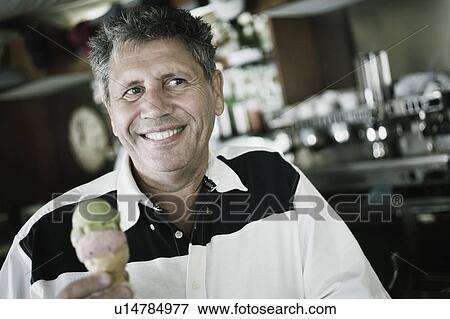 Stock Photo - Close-up of a senior man holding an ice-cream. Fotosearch