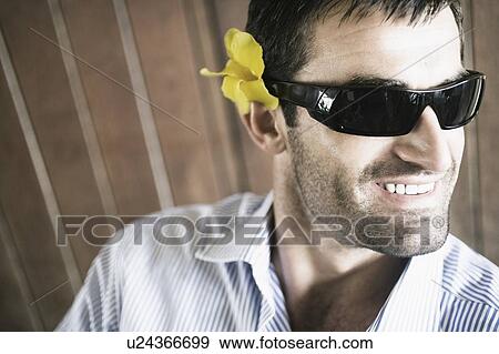Stock Photo - Close-up of a young man wearing sunglasses and smiling. Fotosearch