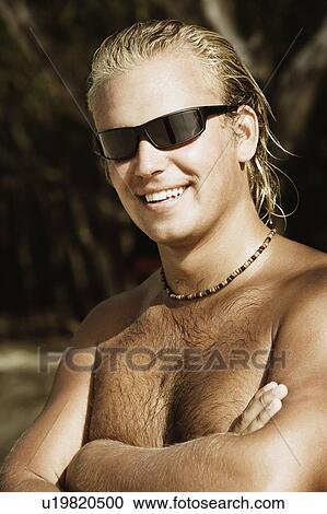 Close-up of a young man with his arms crossed and smiling View Large Photo Image Stock Image - Close-up of a young man with his arms crossed and smiling. Fotosearch