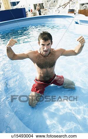 High angle view of a mid adult man flexing his muscles in a swimming pool View Large Photo Image Picture - High angle view of a mid adult man flexing his muscles in a swimming pool. Fotosearch