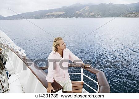 High angle view of a young man standing on a boat deck View Large Photo Image Stock Photo - High angle view of a young man standing on a boat deck. Fotosearch
