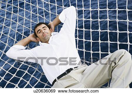 Mid adult man sleeping in the net of a ship View Large Photo Image Stock Photo - Mid adult man sleeping in the net of a ship. Fotosearch