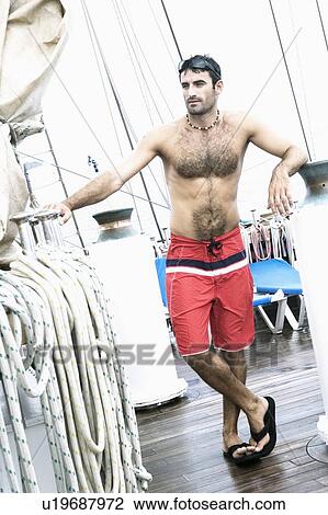 Mid adult man standing with his legs crossed at ankle View Large Photo Image Stock Image - Mid adult man standing with his legs crossed at ankle. Fotosearch