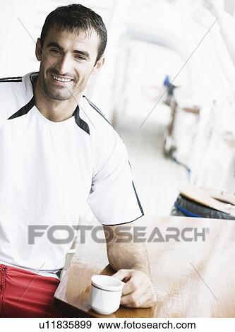 Portrait of a mid adult man smiling and holding a cup of tea View Large Photo Image Stock Photo - Portrait of a mid adult man smiling and holding a cup of tea. Fotosearch