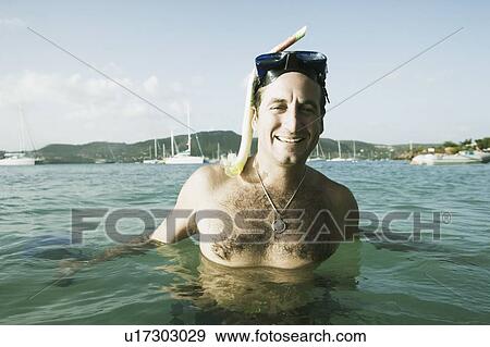 Stock Photo - Portrait of a mid adult woman standing in water and smiling. Fotosearch