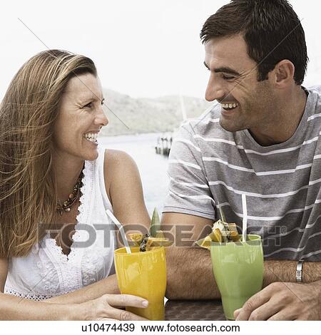 Stock Photo - Close-up of a mid adult couple looking at each other and smiling. Fotosearch