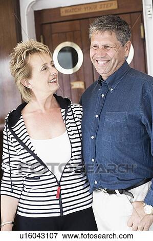 Stock Photo - Close-up of a senior man standing with a mature woman and smiling. Fotosearch