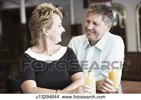 Mature woman sitting with a senior man and smiling View Large Photo Image Picture - Mature woman sitting with a senior man and smiling. Fotosearch