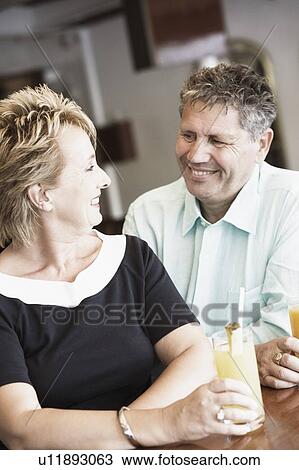 Mature woman sitting with a senior man and smiling View Large Photo Image Stock Image - Mature woman sitting with a senior man and smiling. Fotosearch