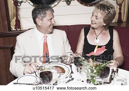 Stock Photo - Mature woman taking food with a senior man and smiling. Fotosearch