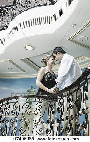 Stock Photo - Mid adult couple romancing at a balcony of a ship. Fotosearch
