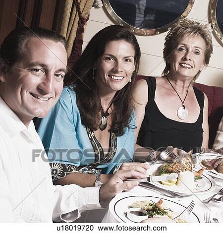 Mid adult couple with a mature woman and a senior man having meal View Large Photo Image Stock Image - Mid adult couple with a mature woman and a senior man having meal. Fotosearch