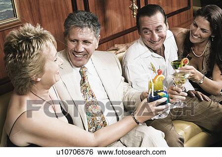 Mid adult couple with a mature woman and a senior man toasting glasses of cocktail View Large Photo Image Stock Photograph - Mid adult couple with a mature woman and a senior man toasting glasses of cocktail. Fotosearch